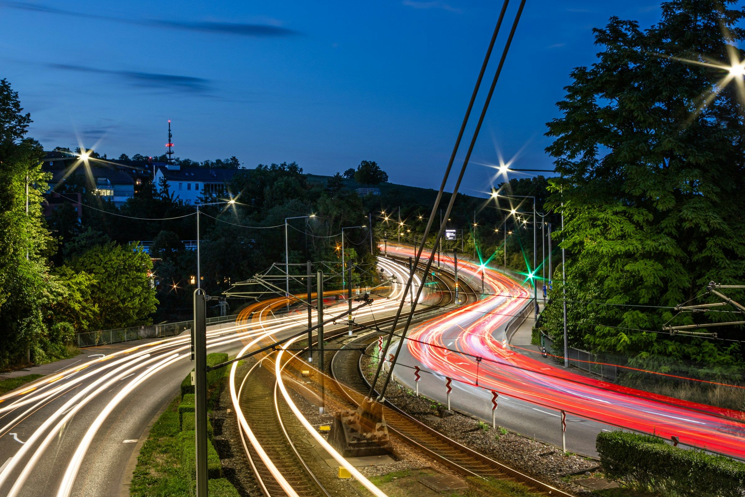 Light trails from a train and road traffic at dusk on a rail line and road in Stuttgart